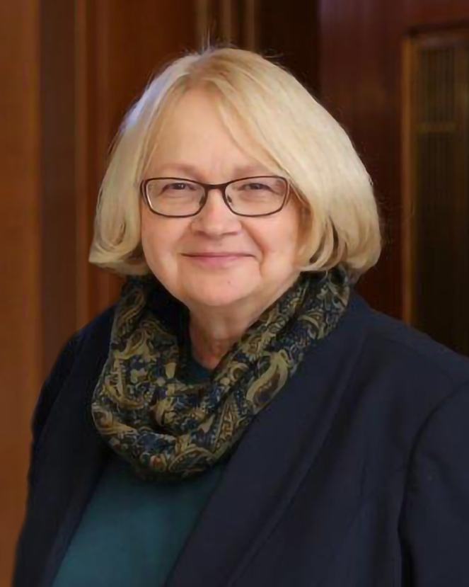 Karlene fine wearing glasses, a scarf, and blue sweater