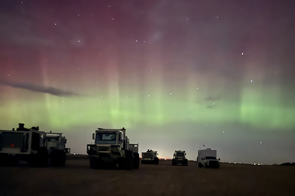 Seismic Survey vehicles in field with Northern Lights in the background