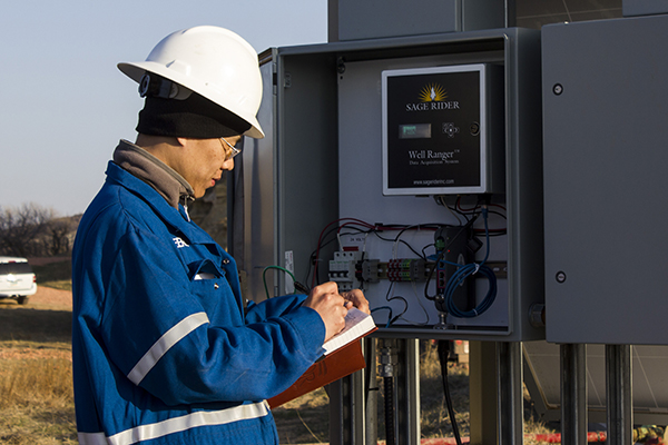 a man in a hard hat, writing on a notepad