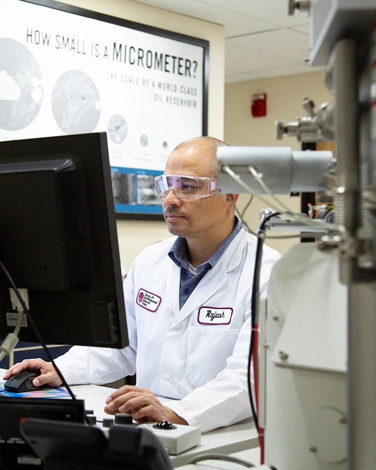 man in a lab coat working at a computer