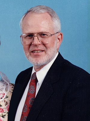 Everett Sondreal wearing a black suit and red tie